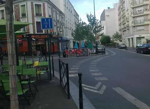 This photo is one example of Paris' "complete street" strategy. It's a one-way street (previously two lanes), reduced to one lane, with more pedestrian area plus a bike lane that allows cycling against the traffic